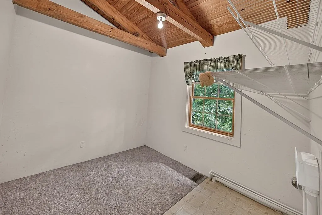 A carpeted upstairs room with windows on two walls
