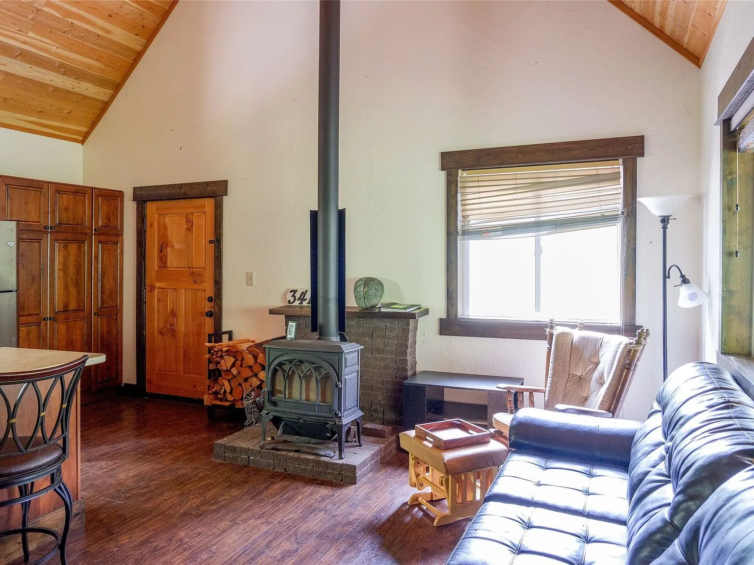 A second living room view with the wood stove and leather sofa