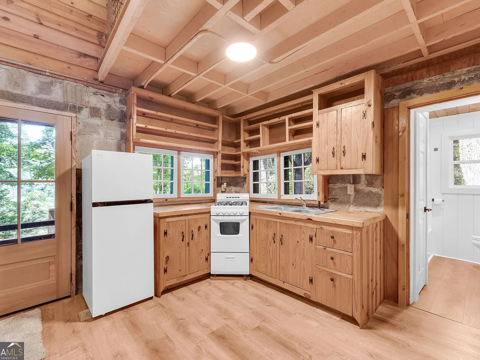 A second bedroom with wood flooring and stone accent wall