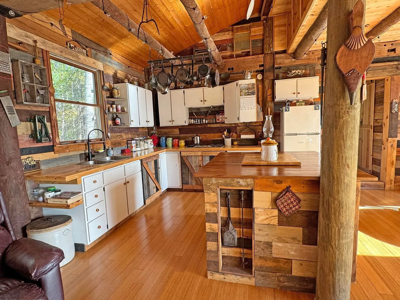 The kitchen counter and island under the log ceiling