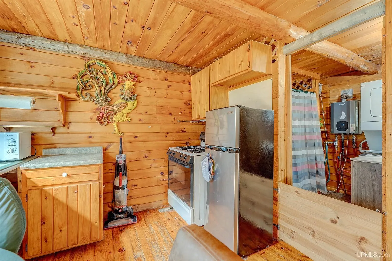 The kitchen with the range, refrigerator and cabinets