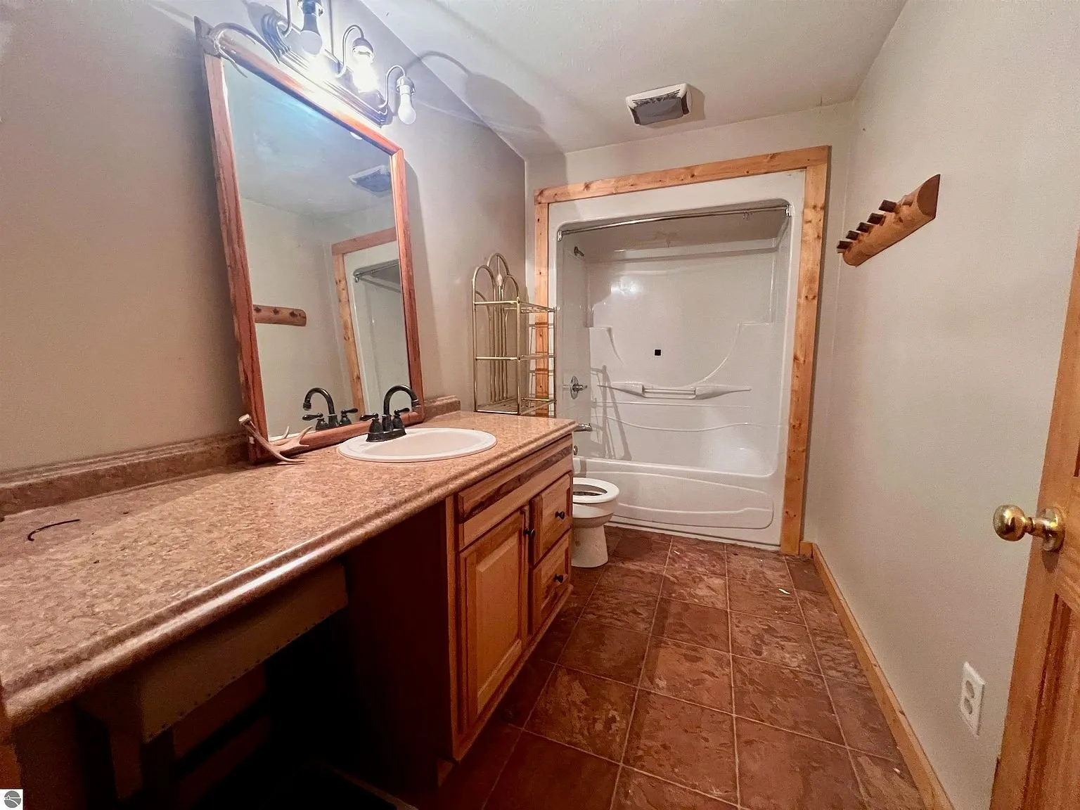 The main bathroom with the long vanity, the mirror and the tub