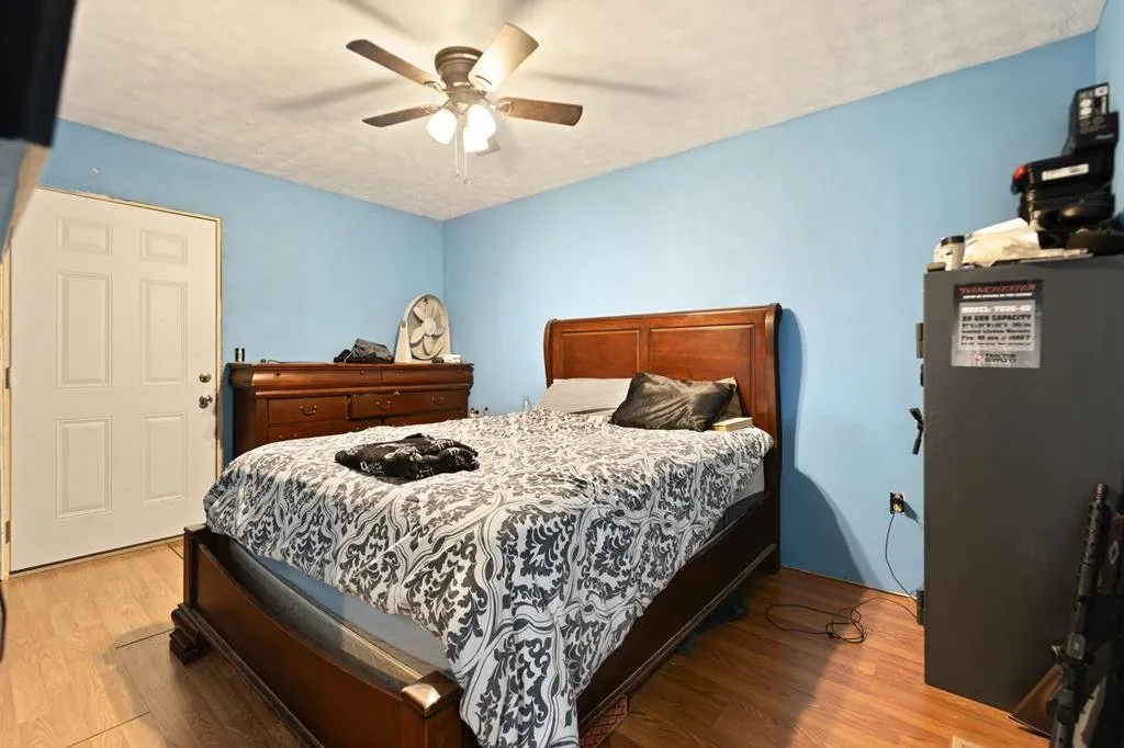The bedroom from the door, wood bed frame and wood floor