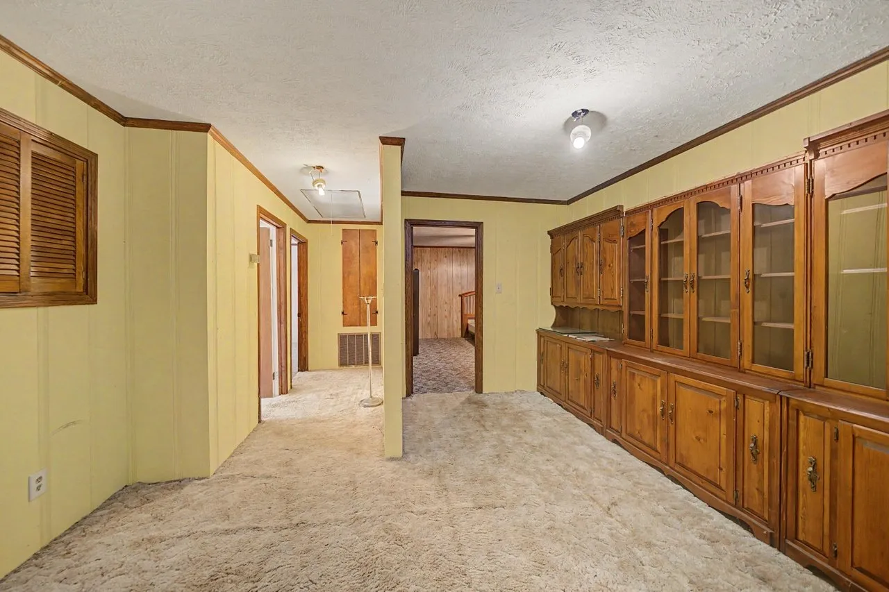 A hallway with built-in cabinets and glass-fronted cupboards