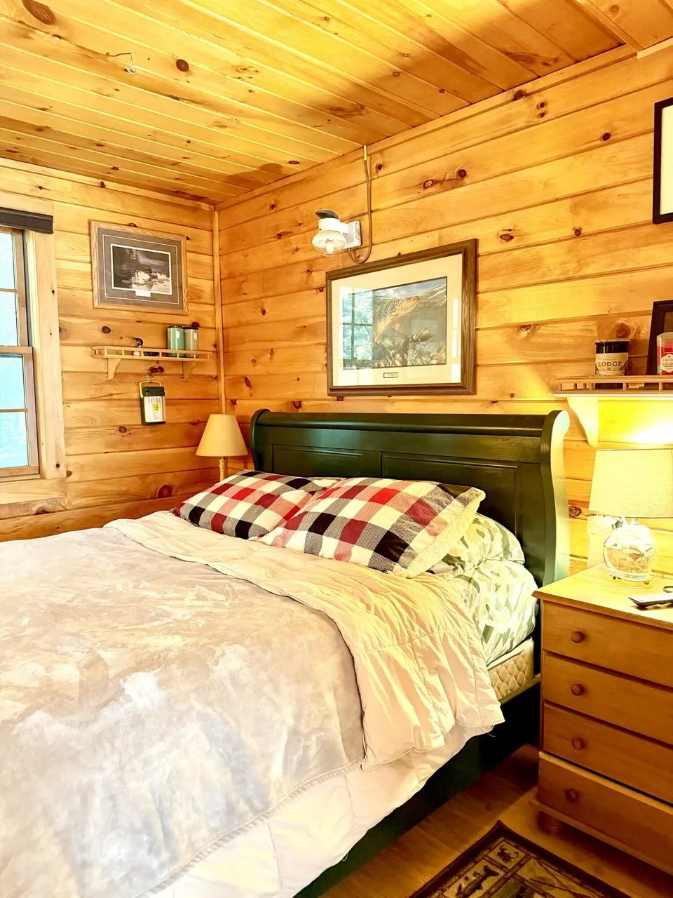 A bedroom with the bed and the quilt under the pine ceiling