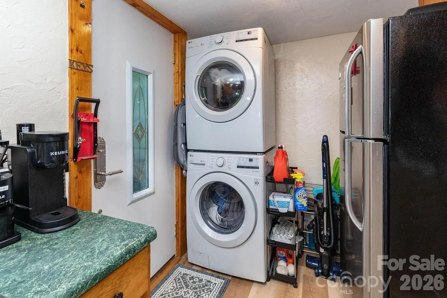 The stacked washer and dryer in the kitchen beside the refrigerator
