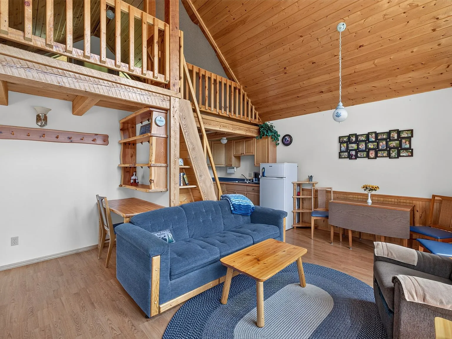 The living room with a wood stove, recliners and a blue sofa