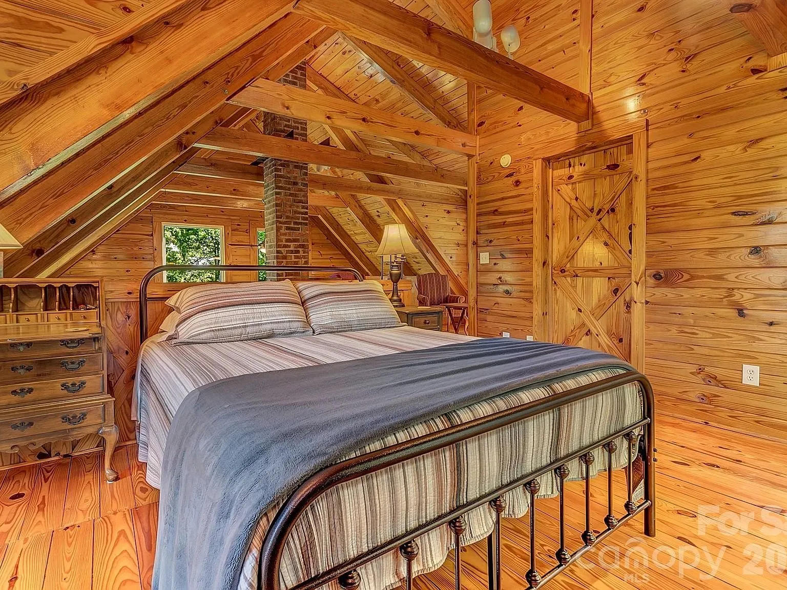 A second view of the loft bedroom with its own exposed beams and window