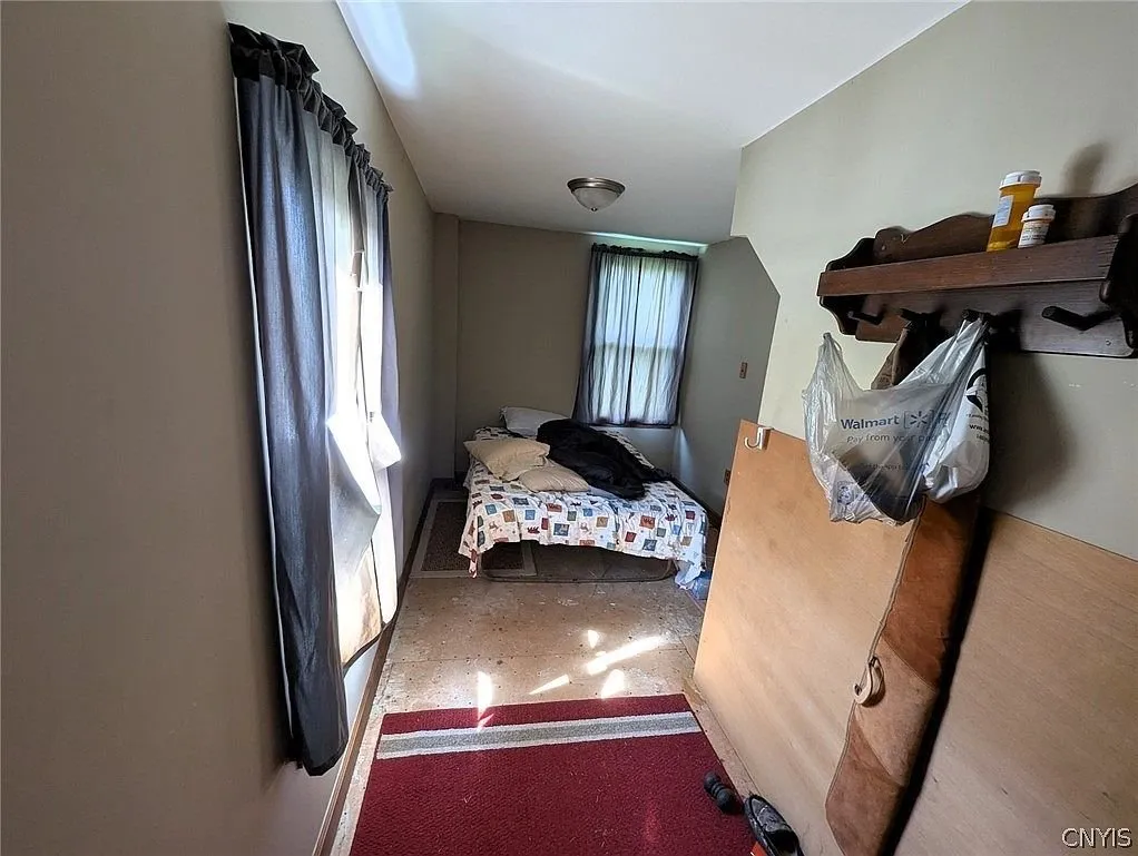 A small bedroom with a bed and a shelf