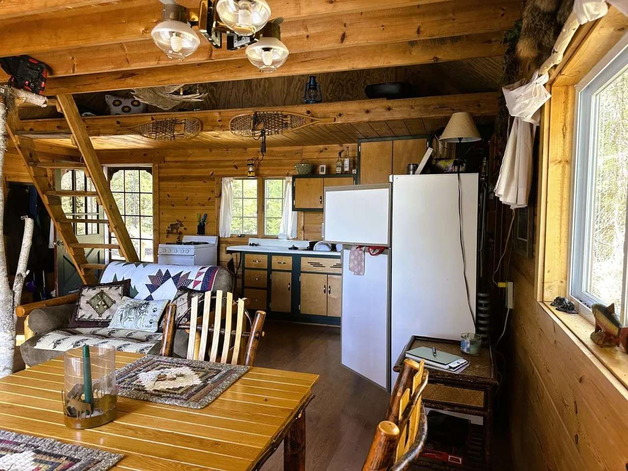 The dining table and chairs under the antler light