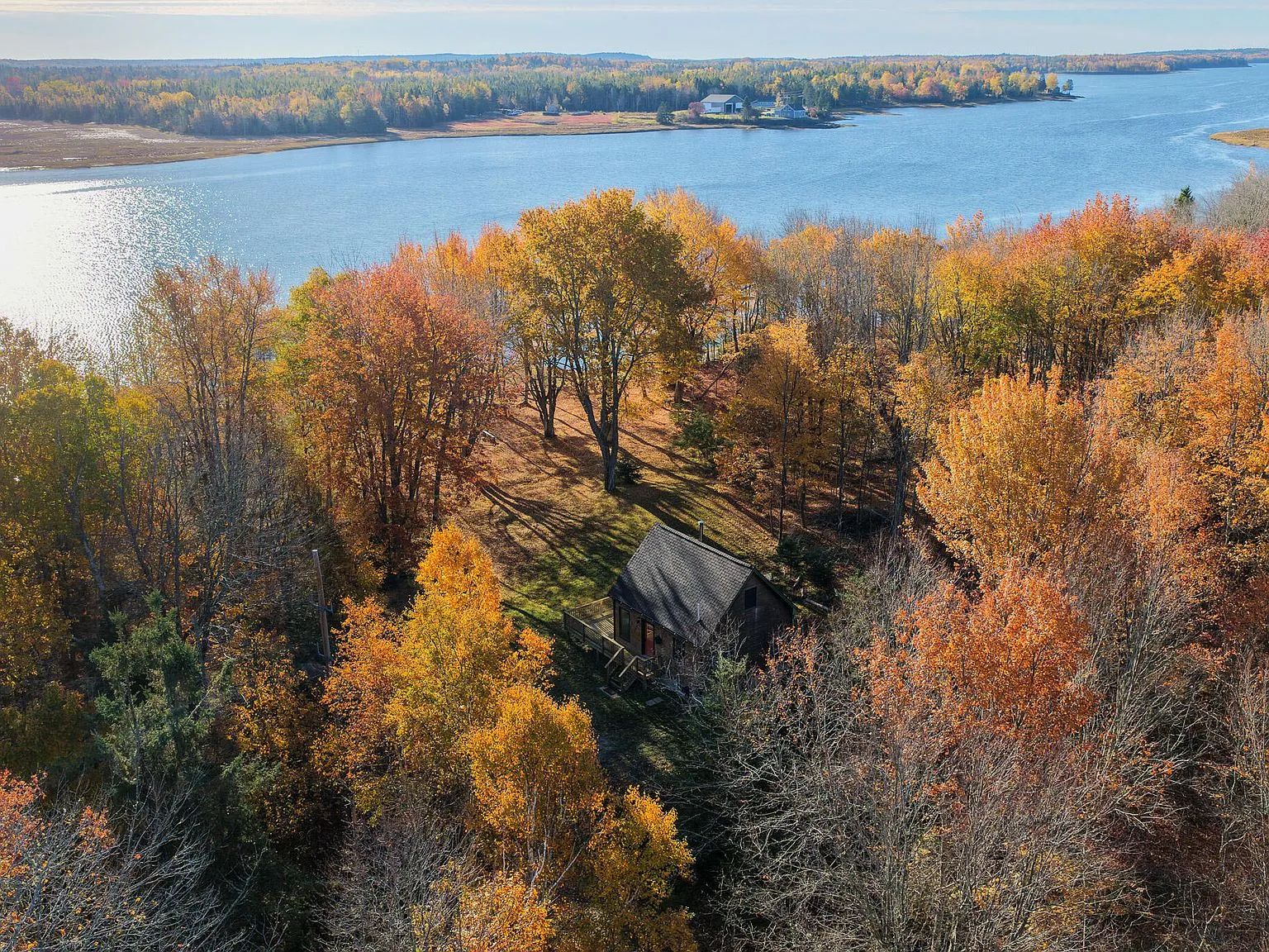 A wide aerial view of the river and surrounding coastal Washington County woods in fall color