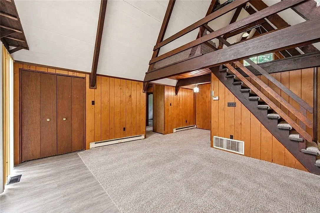 A bedroom with wood paneled walls and a closet