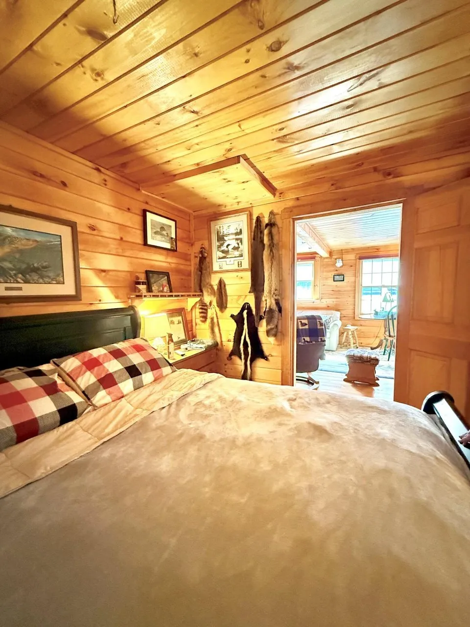 A bedroom with the bed, the window and the pictures on the wall