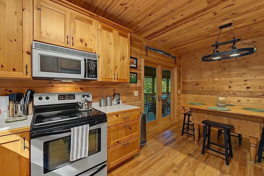 The range, microwave and cabinets along the kitchen wall