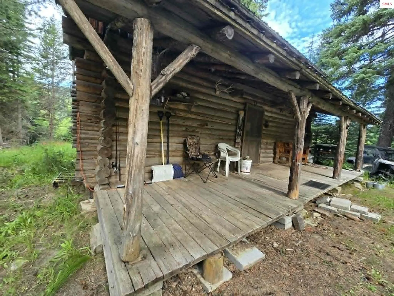 The covered front porch with timber posts and a chair, seen from the yard