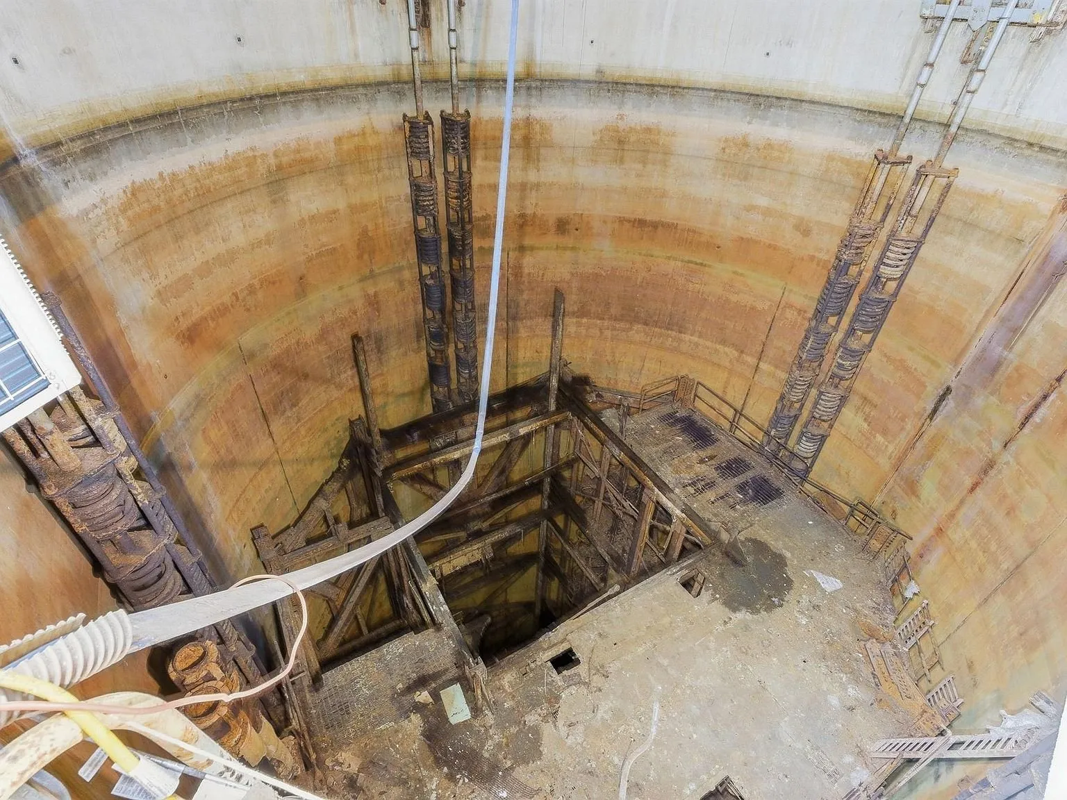 Looking down into the silo's unfinished lower shaft, with rusted equipment racks visible