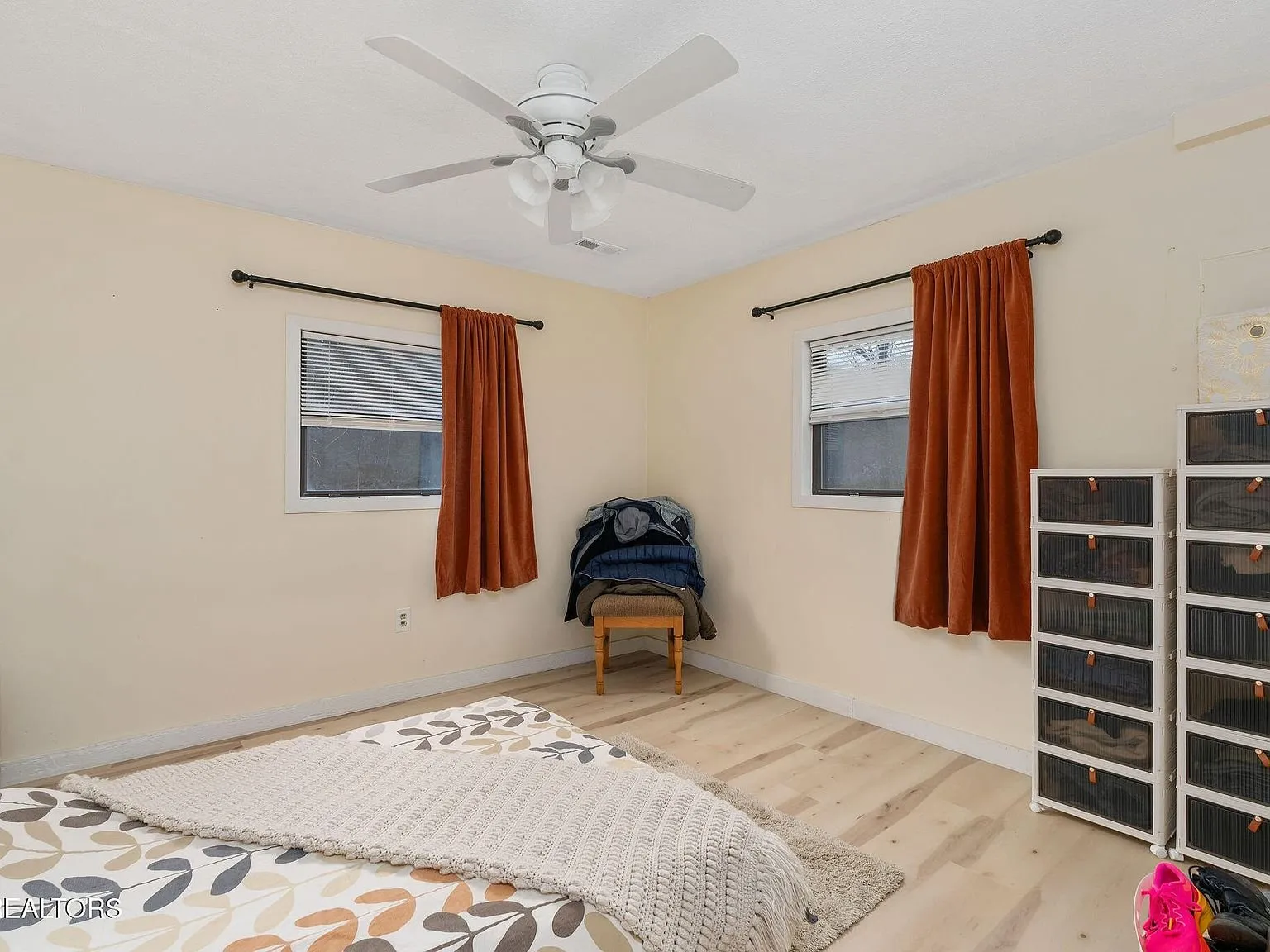 A second bedroom with storage shelving and a bed near the window