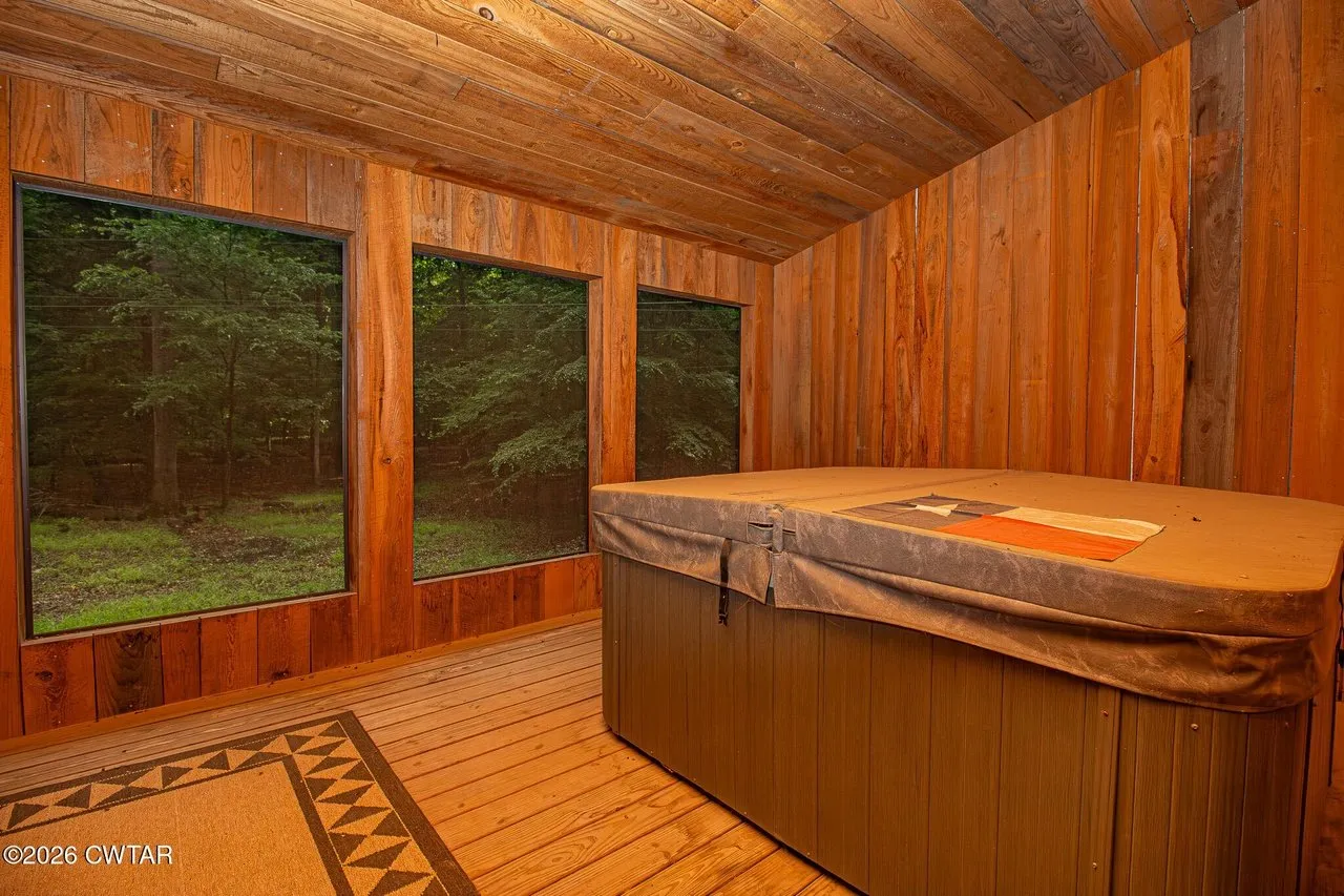 The hot tub on the enclosed porch, windows onto the woods