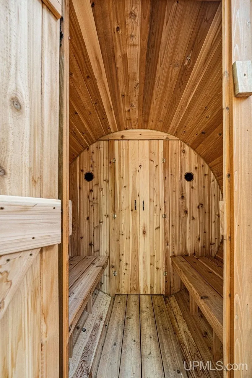 The open door of the barrel sauna showing the cedar interior