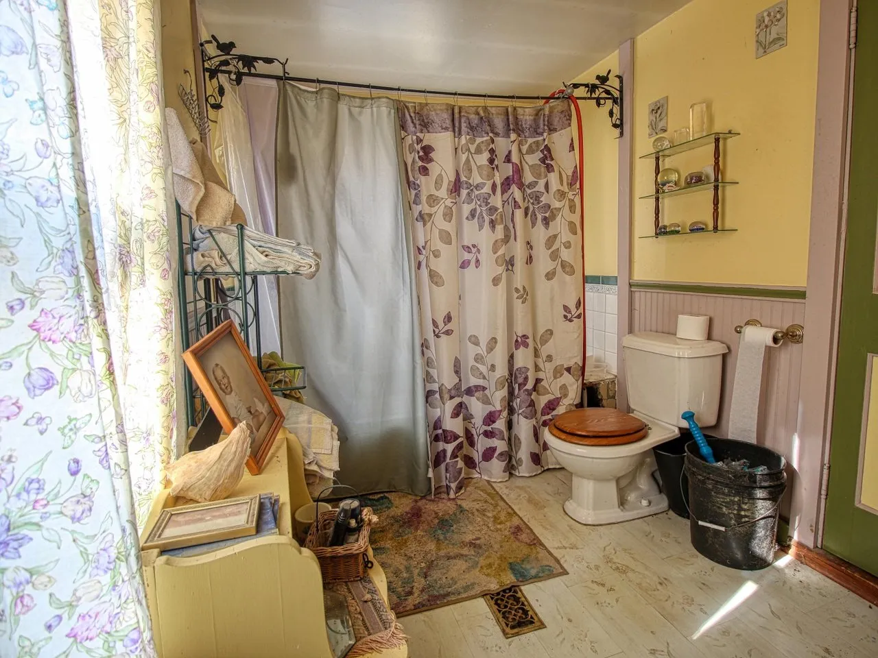 The bathroom's tub with a shower curtain and the toilet beside it