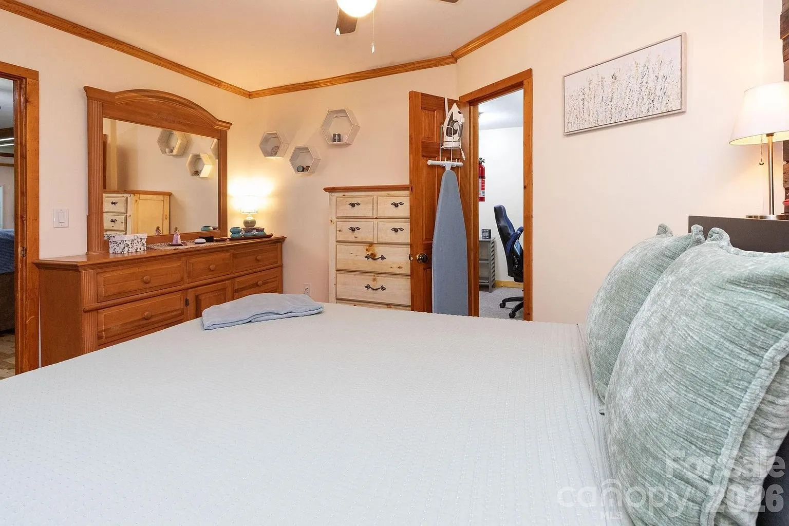 The bedroom with the dresser and the door to the bath
