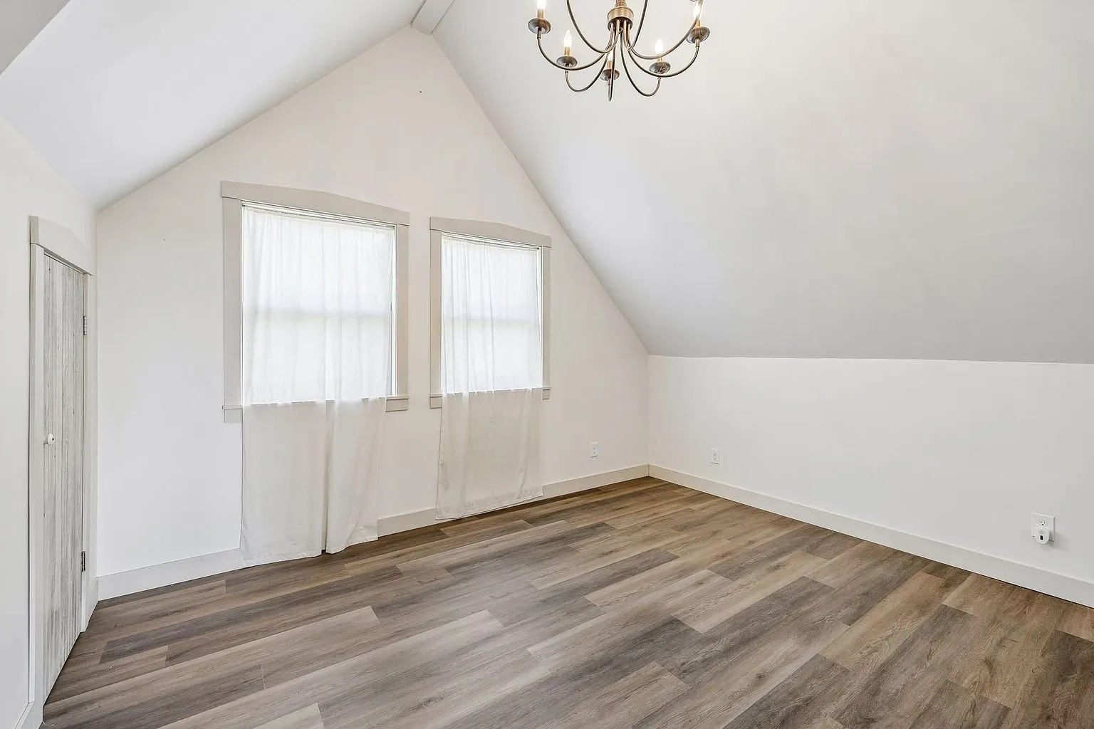 The upstairs room with the two windows and the sloped ceiling