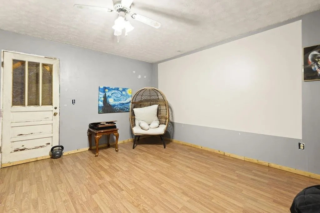 A room upstairs under the roof slope, empty with a ceiling fan