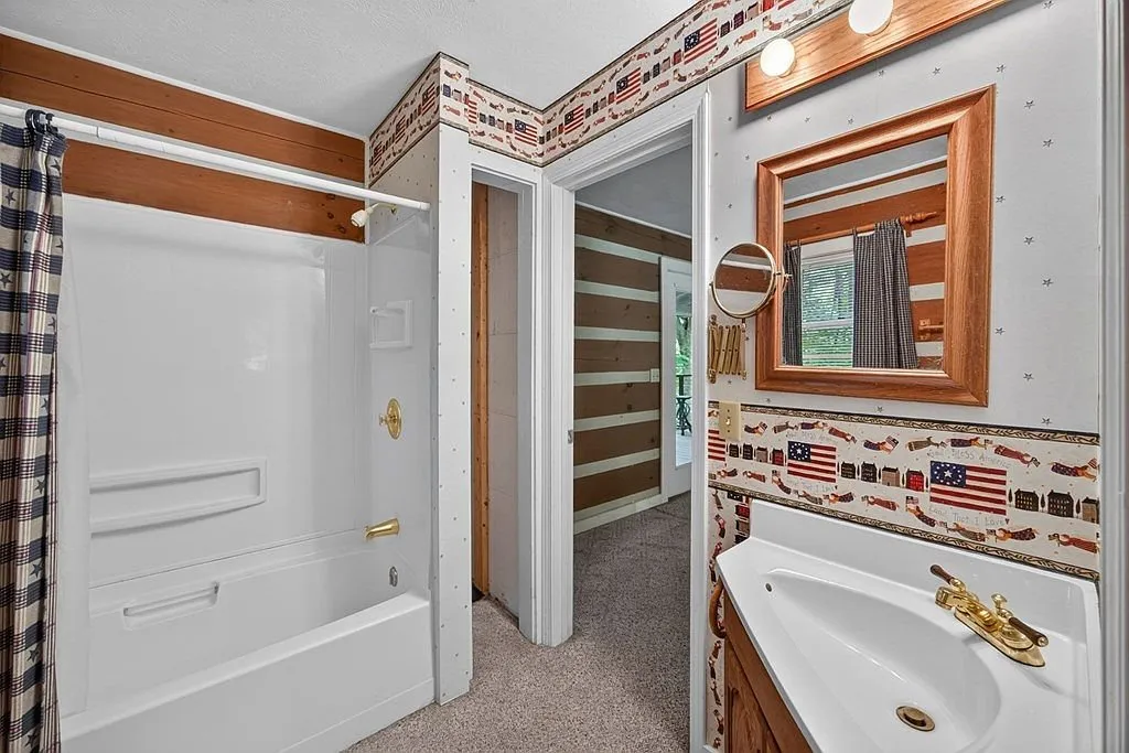 A bathroom with a tiled tub surround and decorative border