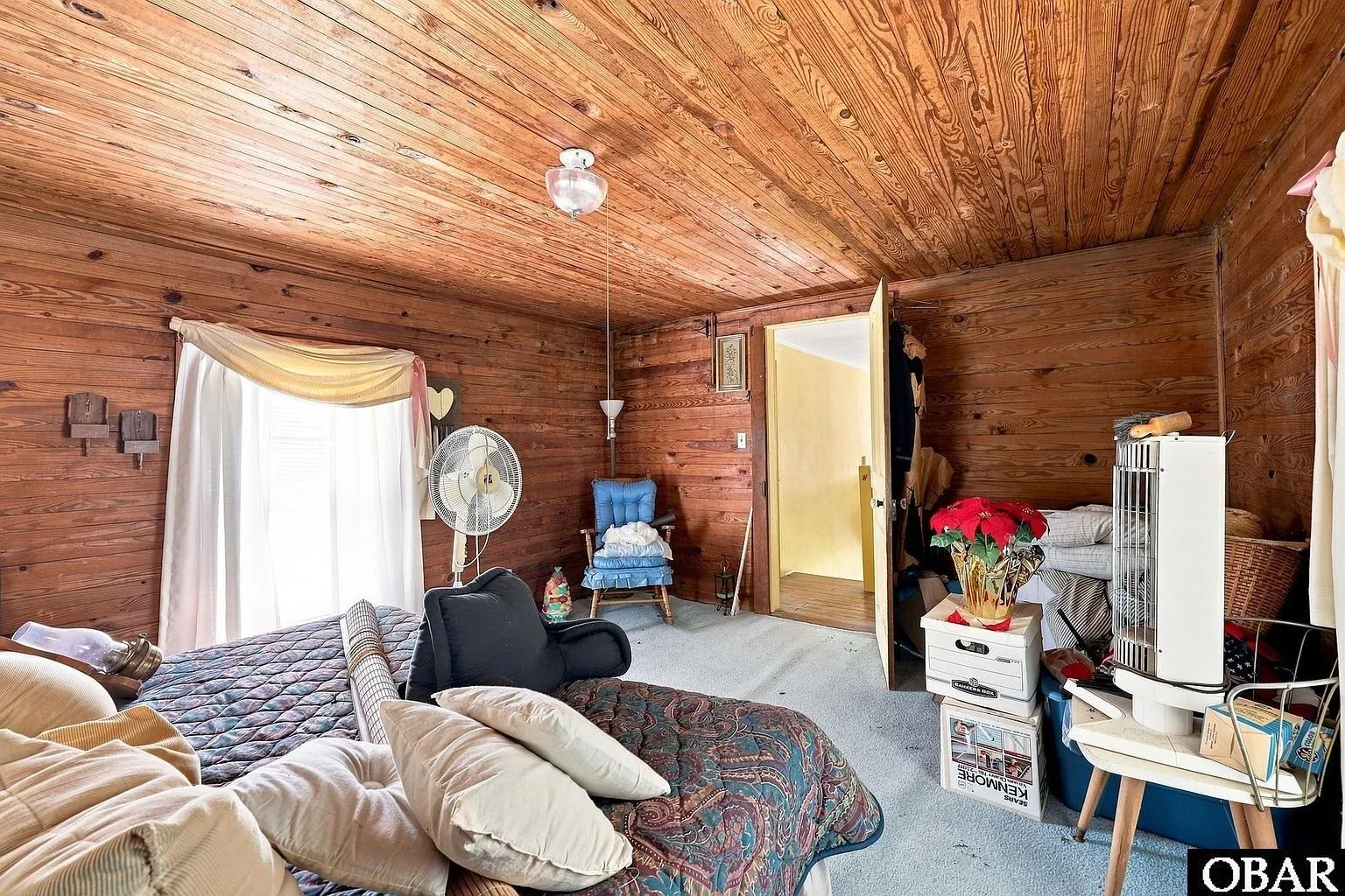 The wood-paneled bedroom looking toward its door