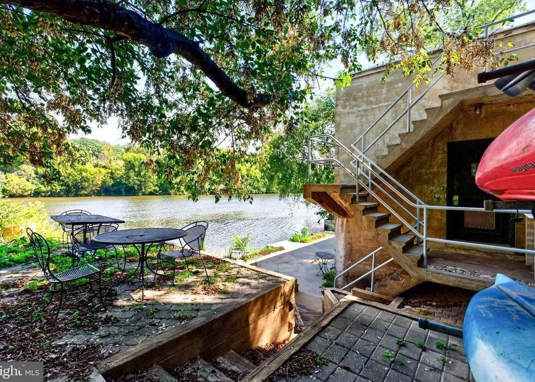 A stepped stone patio with a stairway to The River Room and kayaks stored nearby