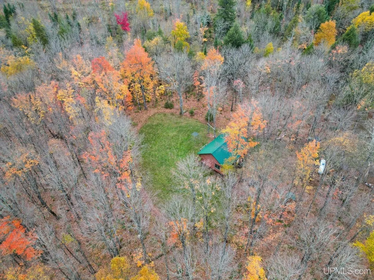 Aerial across the parcel with the cabin clearing at the edge of frame