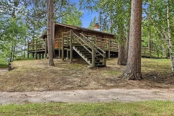 The first cabin with the stairs to the deck and the pines