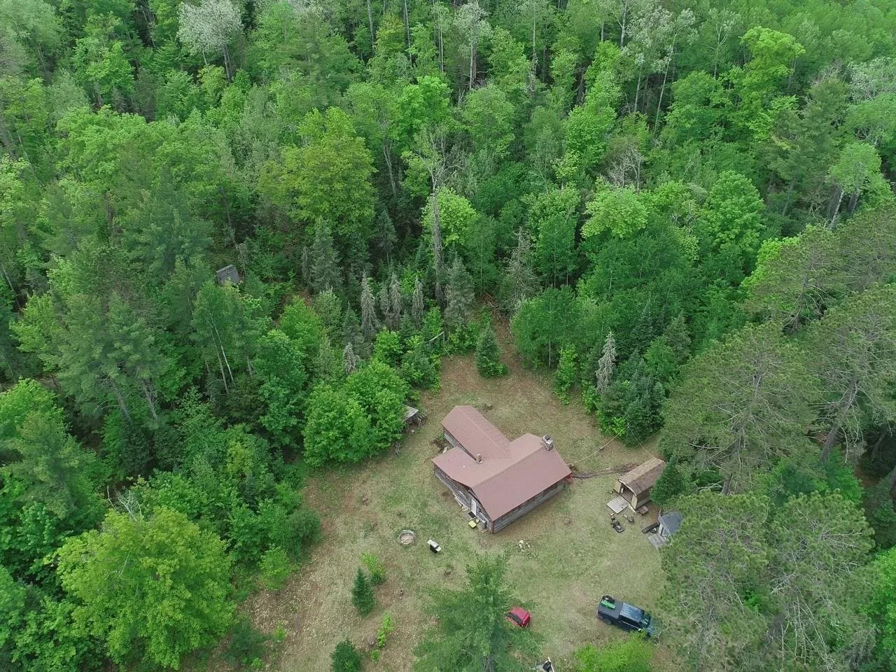 The camp in its clearing from the air, surrounded by unbroken timber