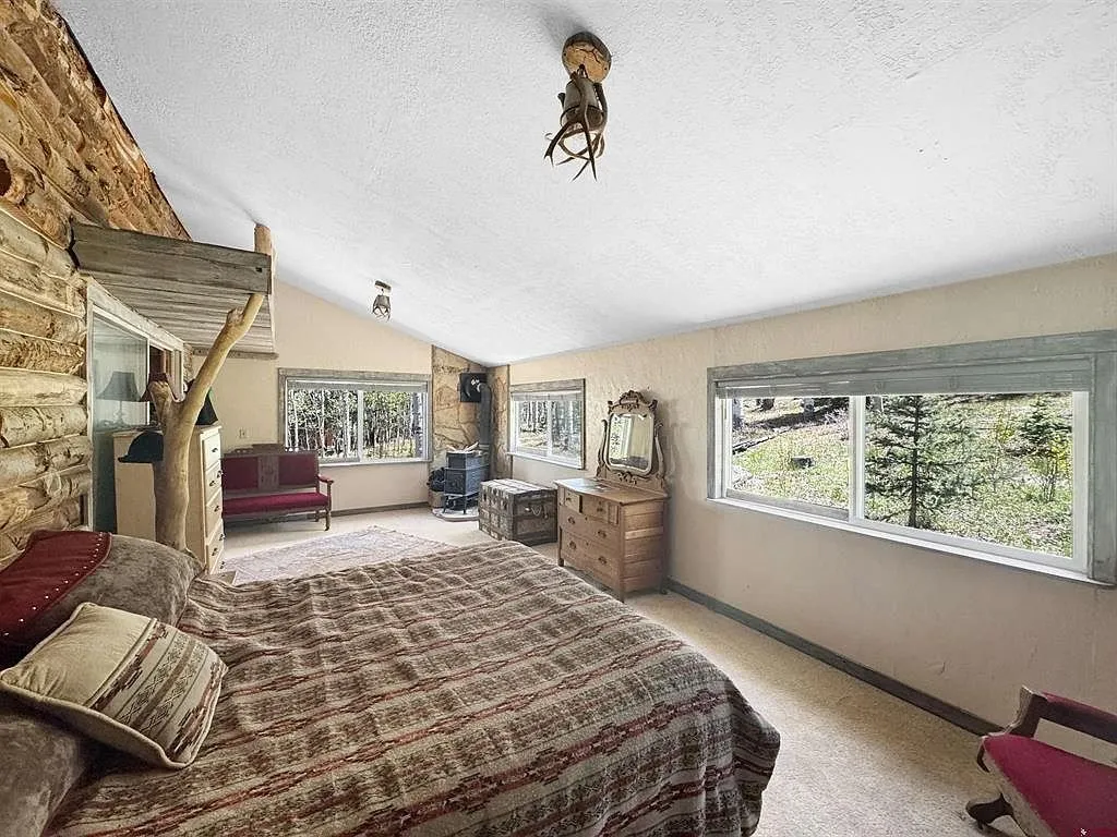A bedroom with the bed under the window and the dresser