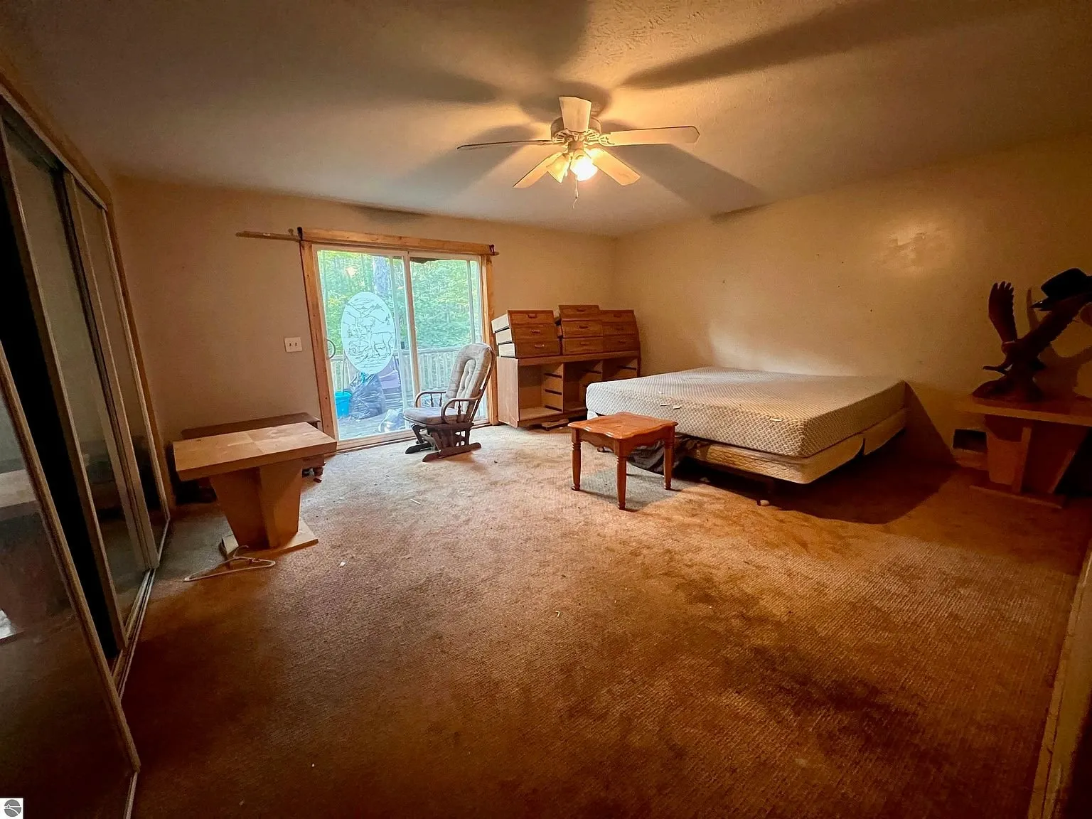 An upstairs bedroom with the mattress and the sliding door to the balcony