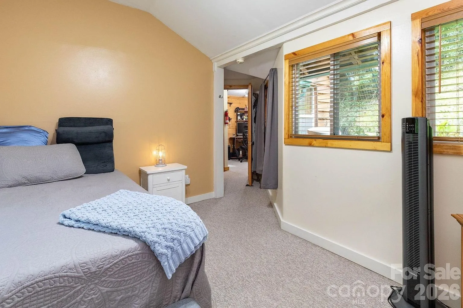 A bedroom with the sloped ceiling and the window