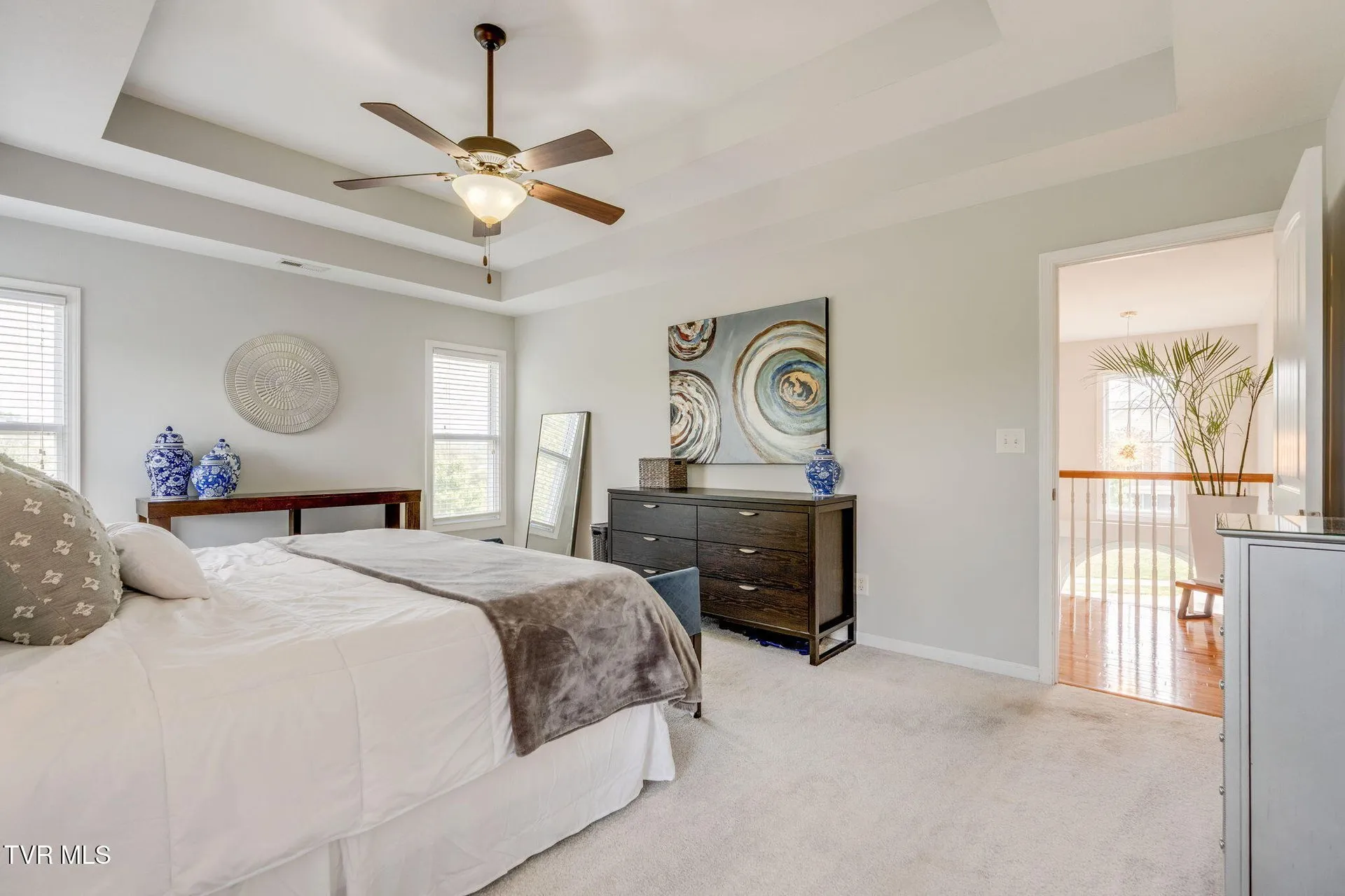 The primary bedroom with the bed, bench and dresser