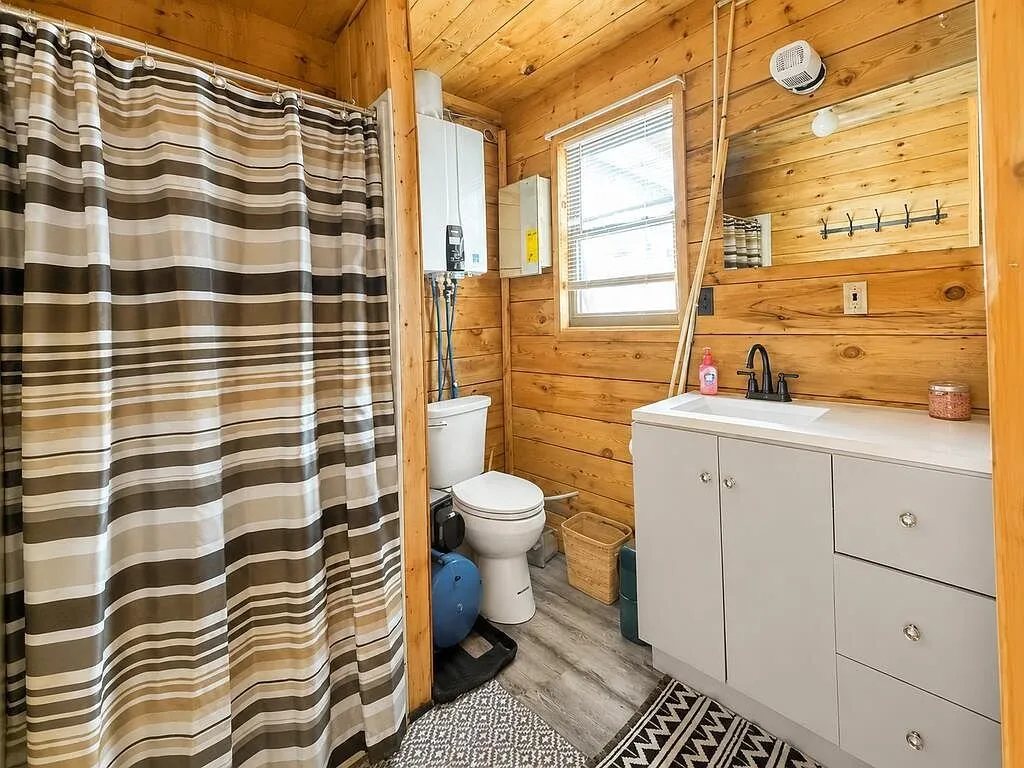 The bathroom with the shower curtain, toilet and vanity