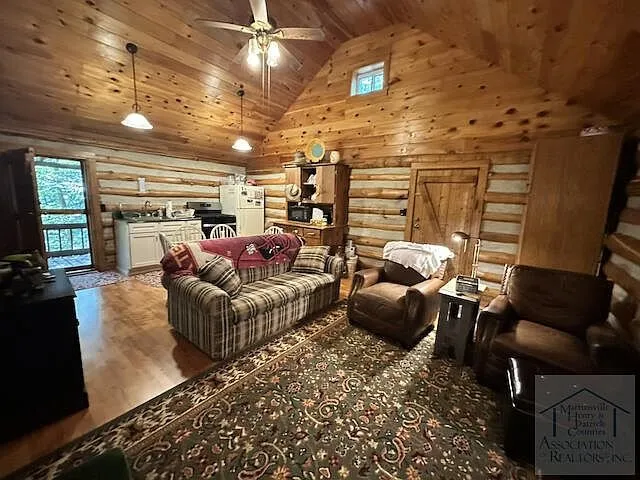 The living area with couch and armchairs under the cathedral ceiling