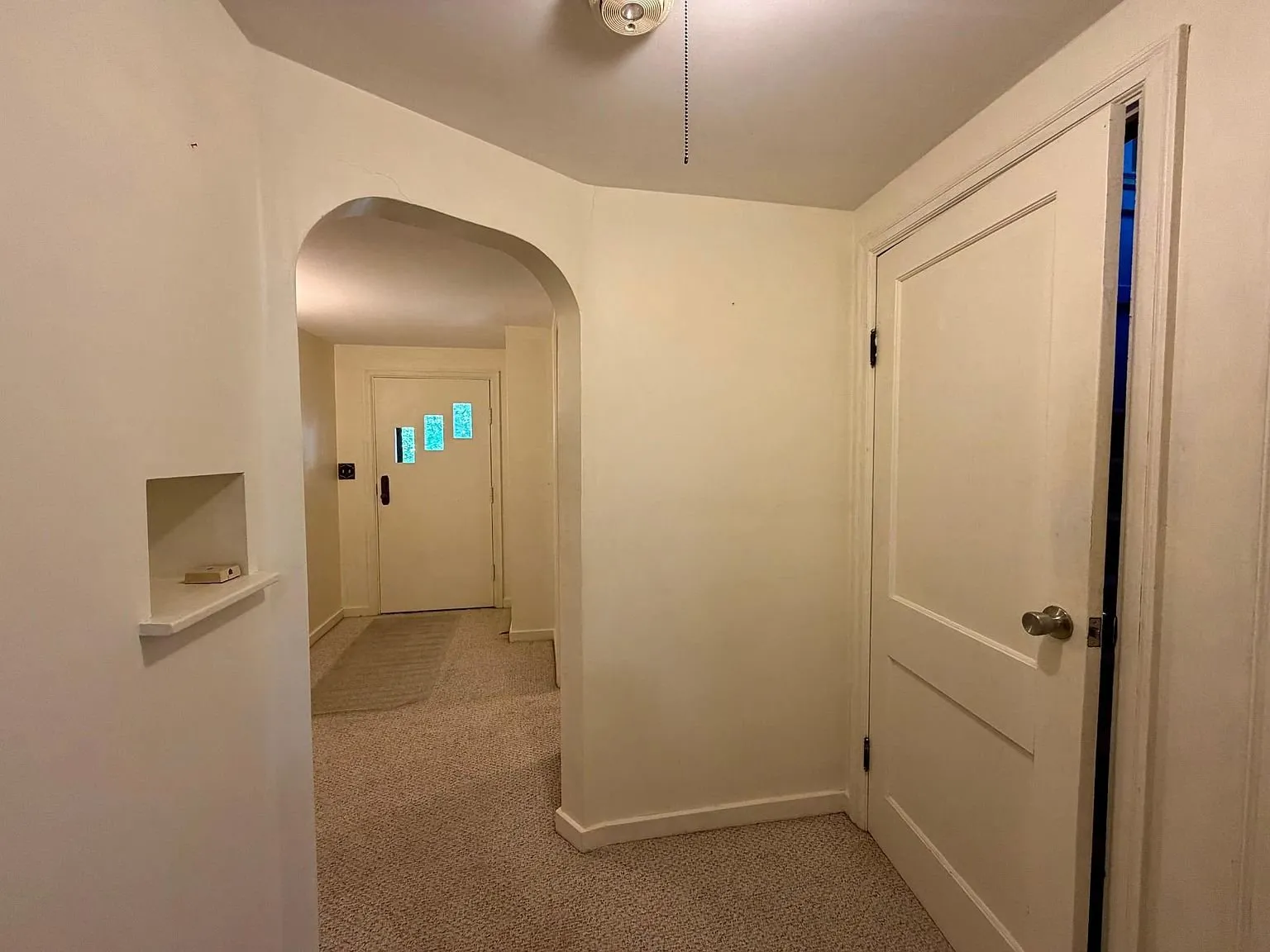 The foyer with the arch and the door