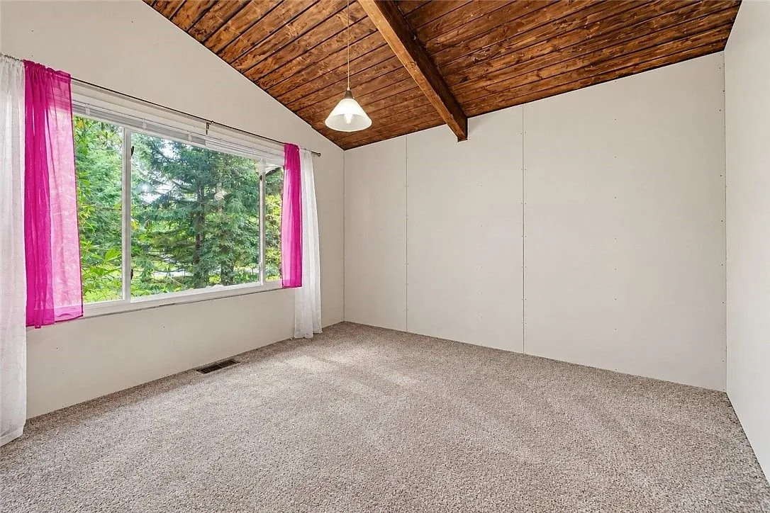An empty bedroom with a closet door and a baseboard heater