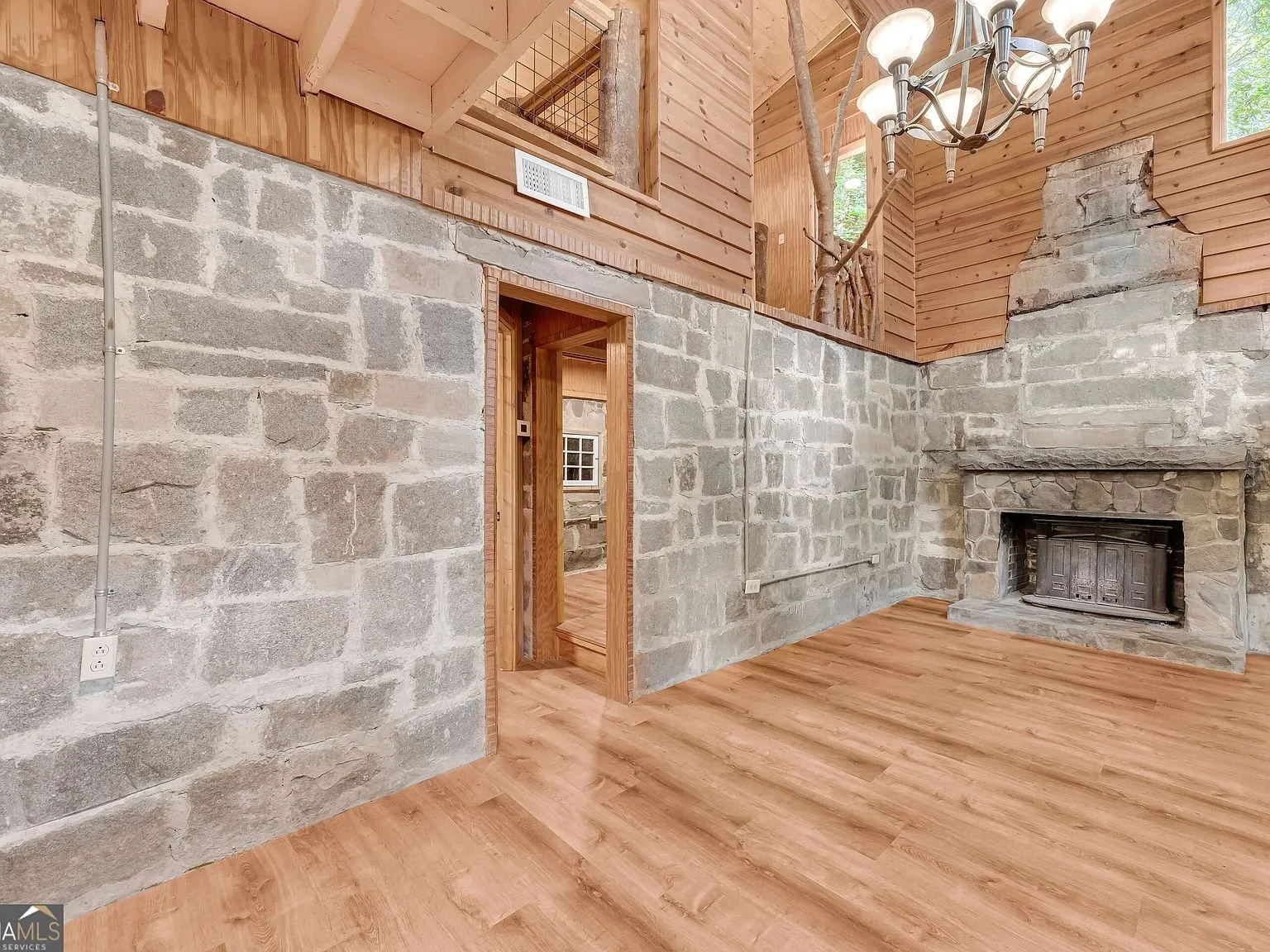 A stone-walled room with a second fireplace opening