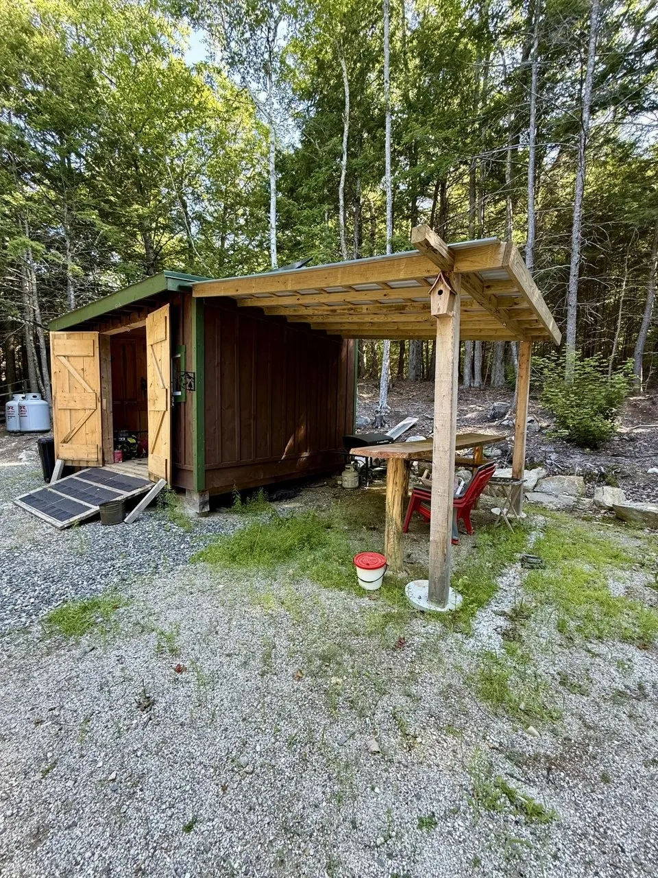 The storage shed with a lean-to in the trees