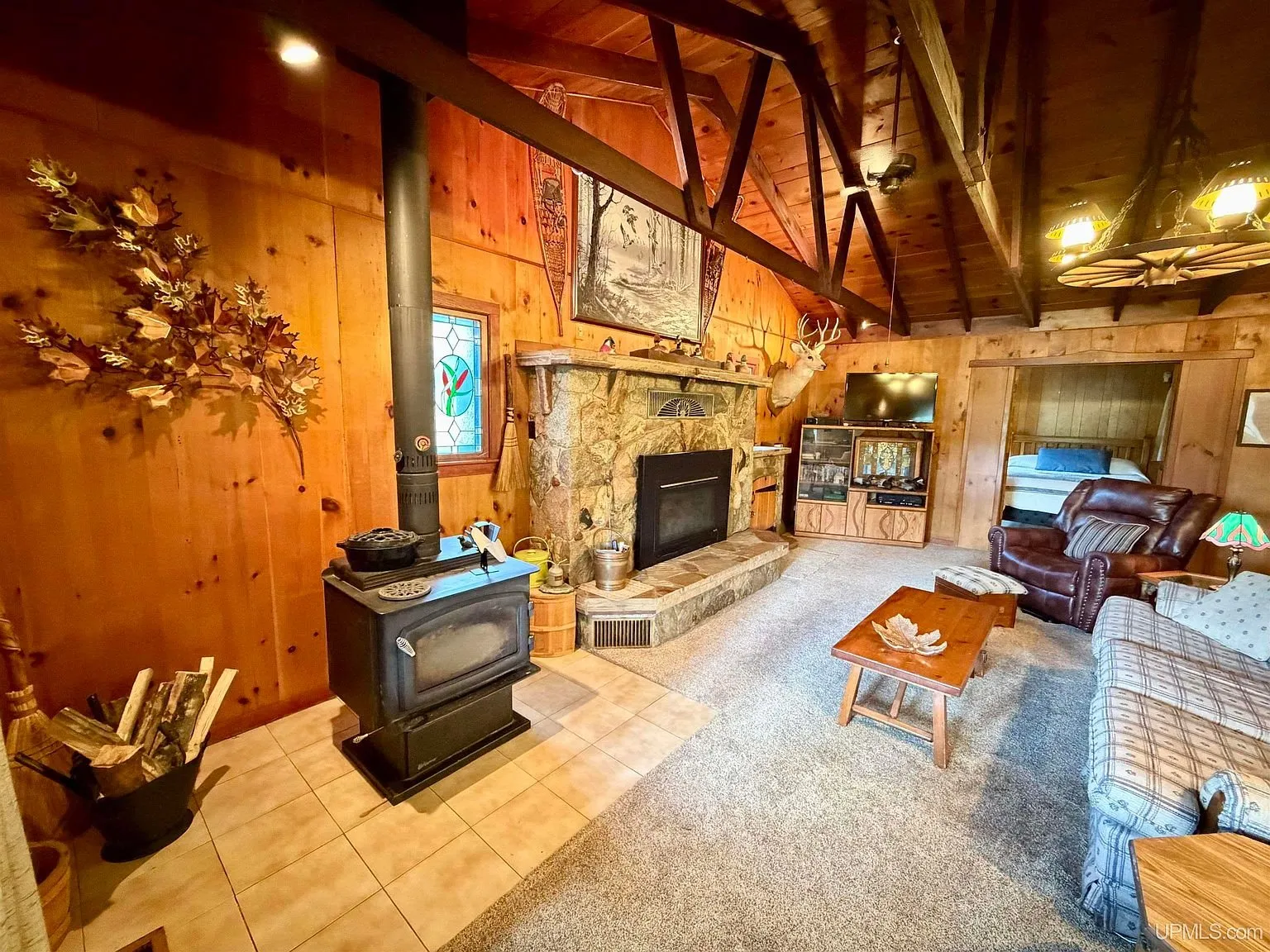 The wood stove on its stone hearth beside the fireplace