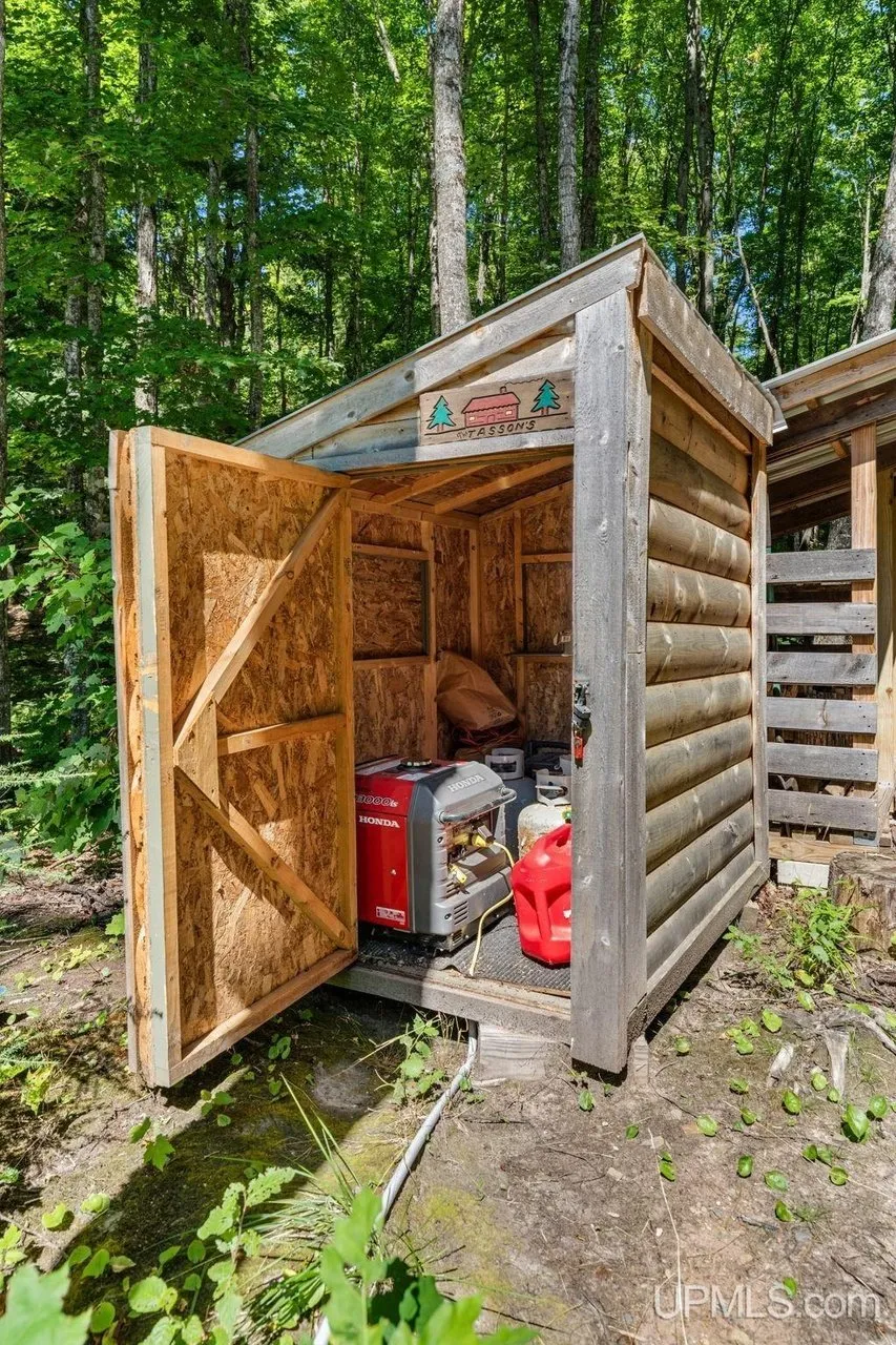 An open woodshed with equipment stored inside