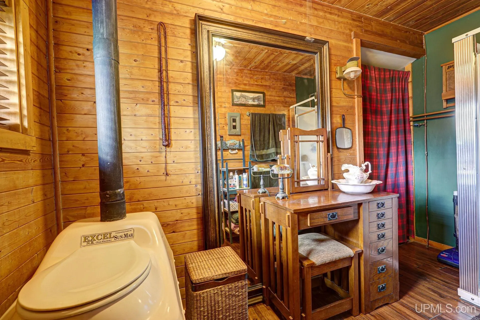 The bathroom with a toilet and a vanity under the window