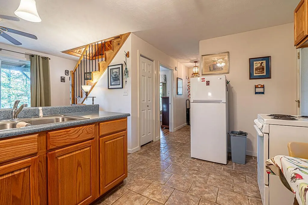 A second kitchenette nook with a range, curtained window and bistro table
