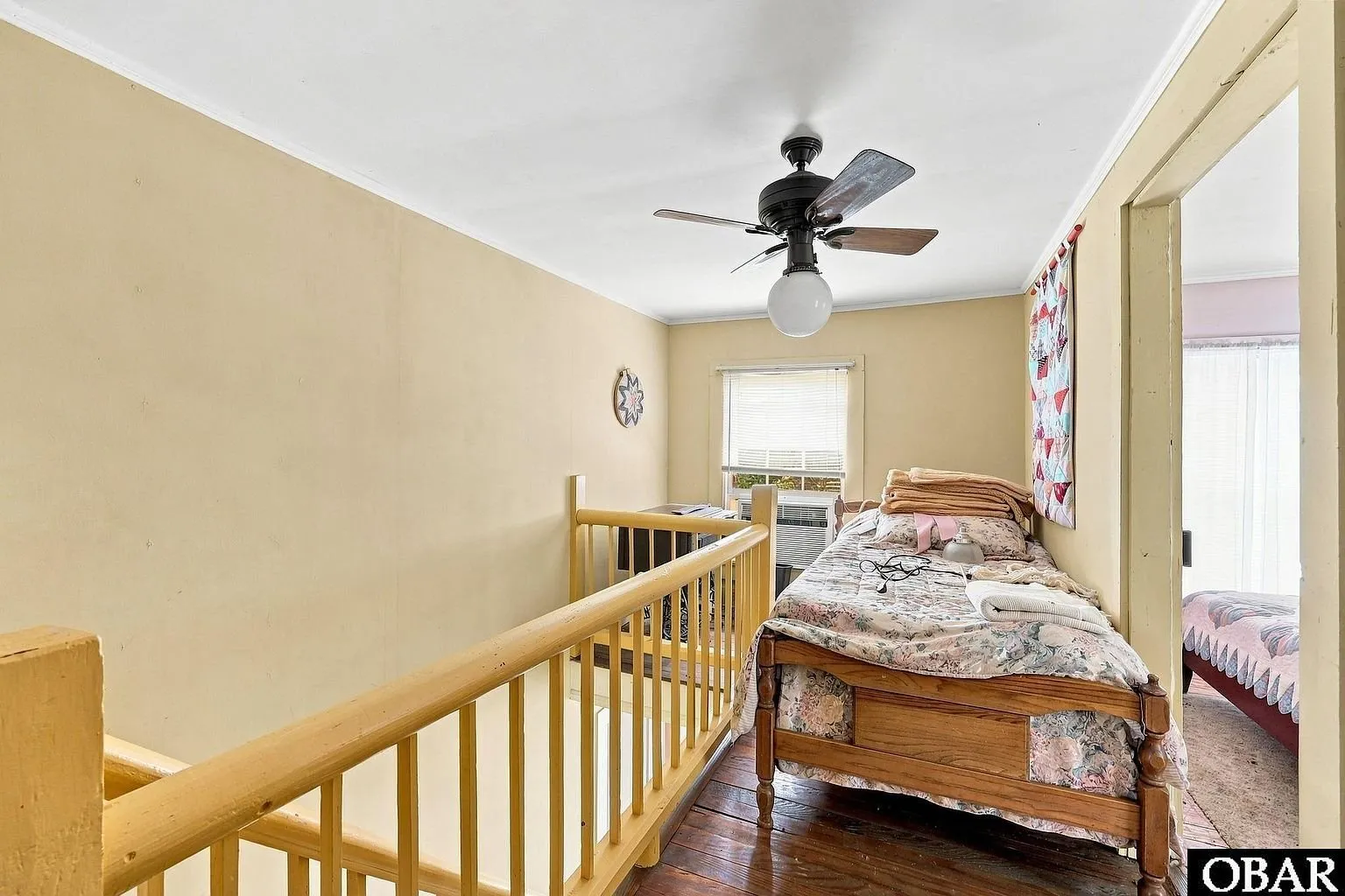 The upstairs hall with the stair rail and a bedroom beyond