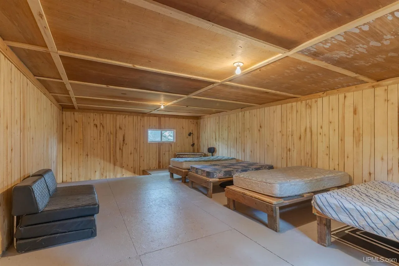 The bunk room from the other end under the pine ceiling