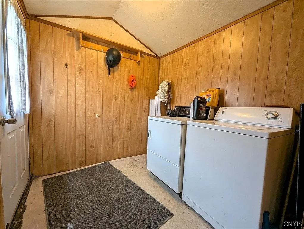 The laundry room with the washer and dryer and pine walls